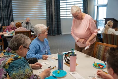 Residents engaging in an activity at a communal table.
