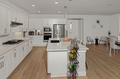 Modern kitchen with white cabinetry and appliances.