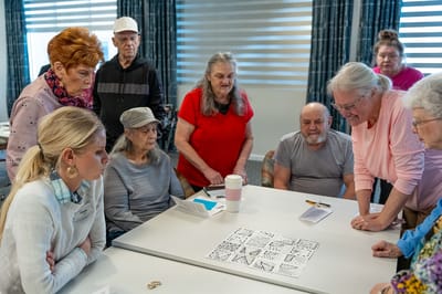 Residents engaged in a group activity around a table.