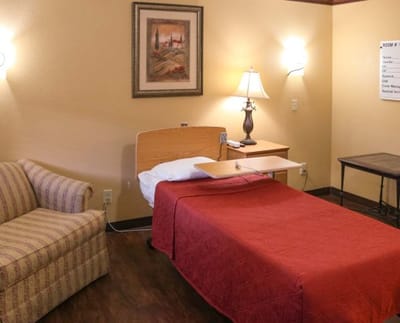 A private resident room with a bed and seating area.