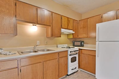 Cozy kitchen with wooden cabinets and appliances.