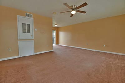 Empty living room with a ceiling fan
