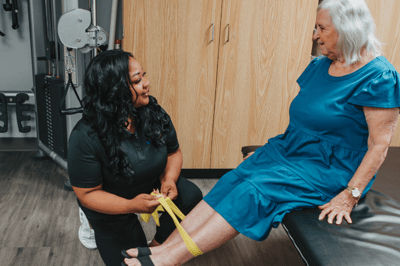 Staff assisting a resident with therapy exercises.