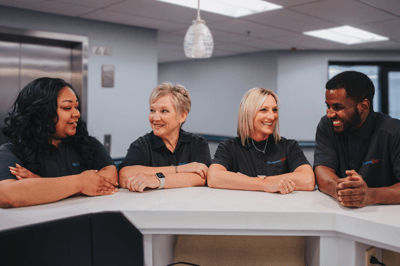 Smiling staff members at a reception area.