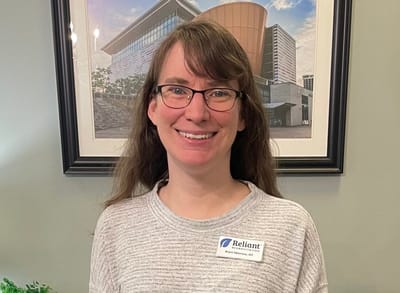 Staff member posing in front of a facility background.