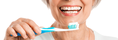 Elderly woman smiling with a toothbrush.