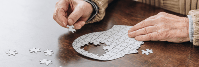 Hands assembling a puzzle on a table