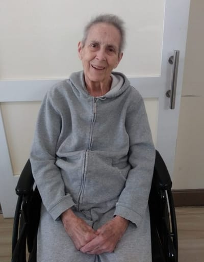 Smiling resident in a wheelchair indoors