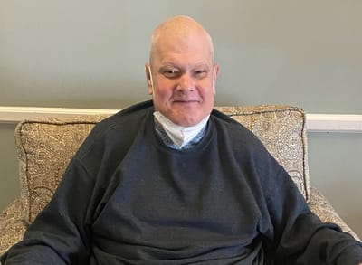 Resident smiling while sitting in a cozy chair