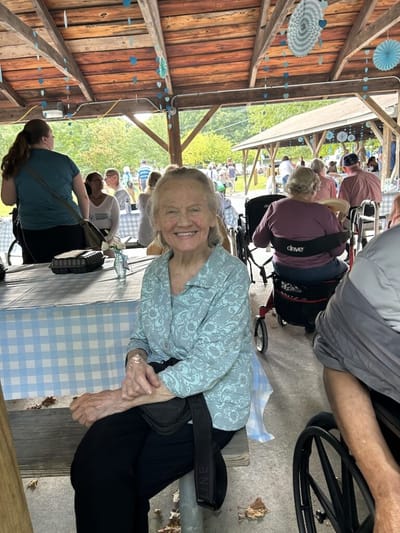 Smiling resident at an outdoor social gathering.