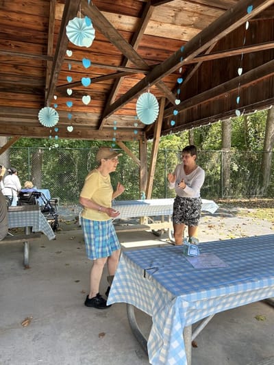 Residents and staff enjoying activities under a pavilion