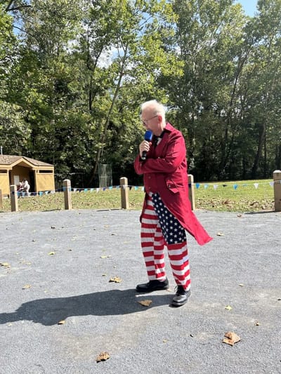 Person in festive outfit speaking outdoors