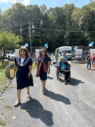 Residents and staff walking outdoors at an event.
