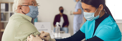 Healthcare professional administering a vaccine to a resident.