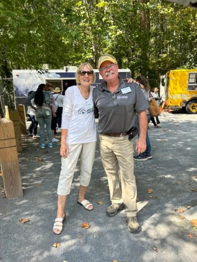 Two staff members smiling outdoors.