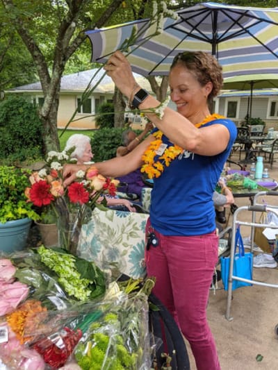 Volunteer arranging flowers at an outdoor event.