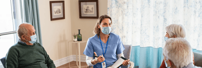 Nurse interacting with seniors in a common area.