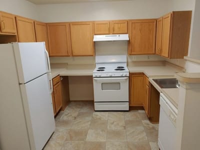 Interior view of a kitchen with cabinets and appliances.