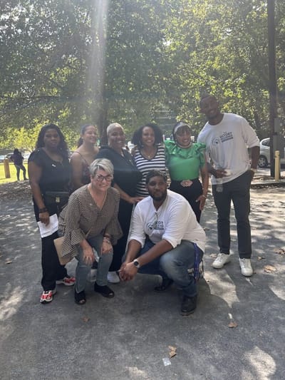 Group of staff and residents outside smiling together.