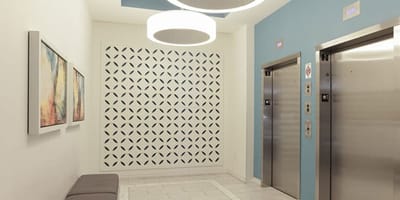 Interior hallway with elevator access and decorative wall.