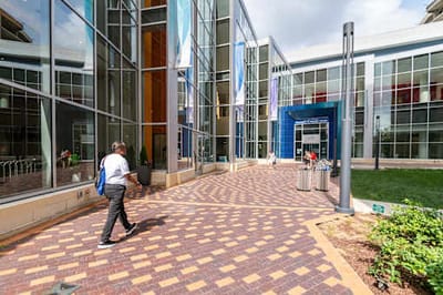 A person walking in front of facility entrance.