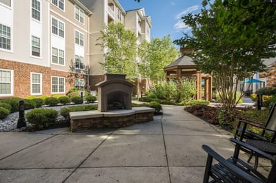 Quiet outdoor seating area with greenery and a fire feature.