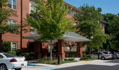 Exterior view of assisted living facility with trees.