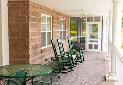Rocking chairs on a porch outside a facility