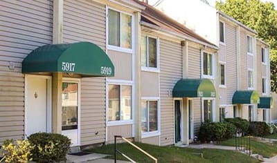 Exterior view of residential units with green awnings