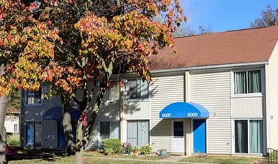 Exterior view of residential building with fall foliage.