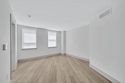 Empty room with hardwood flooring and windows