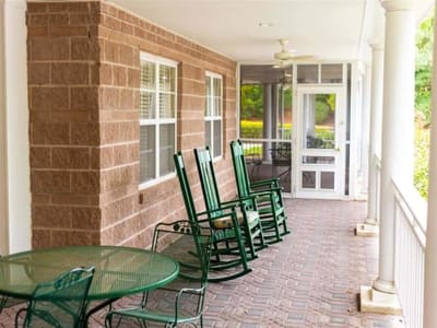 Outdoor porch with rocking chairs and tables