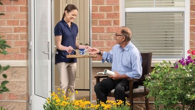 Caregiver serving a resident outdoors