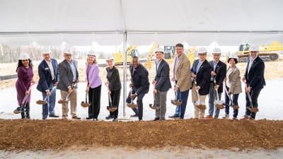 Groundbreaking ceremony with diverse group and shovels