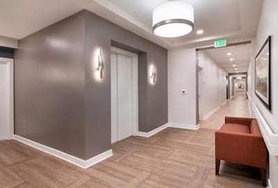 Interior hallway featuring elevators and seating.