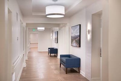 Well-lit hallway with seating and artwork