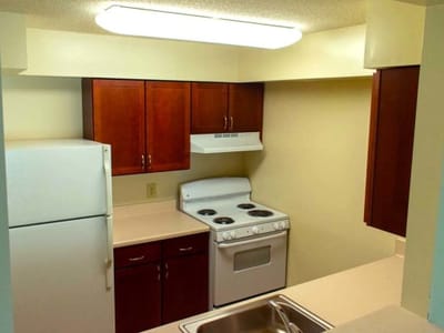 A kitchen area with appliances and cabinets.