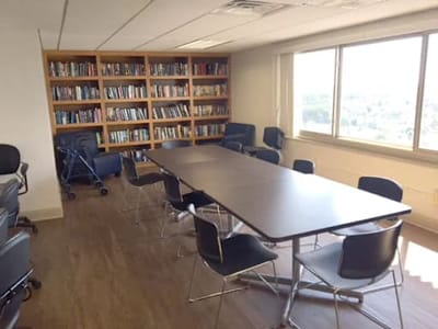 A meeting room with a long table and bookshelves.