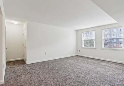 Empty interior room with carpet and windows