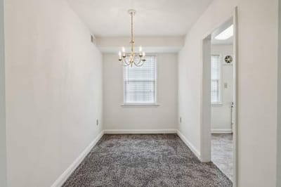 Empty interior room with chandelier and carpet