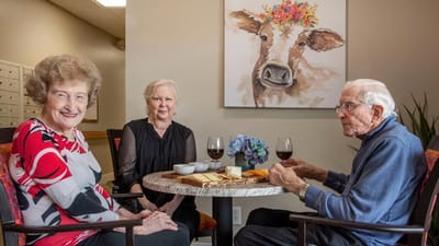 Residents enjoying wine and cheese in a cozy setting