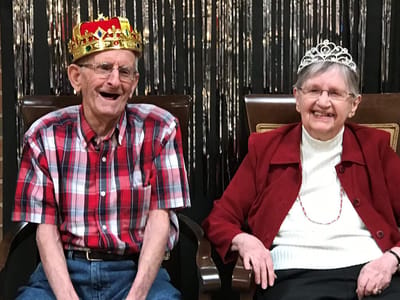 Two residents wearing crowns, smiling at the camera