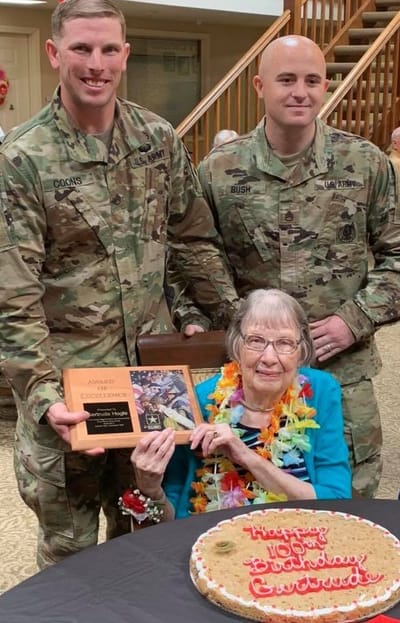 Residents celebrating a birthday with military personnel