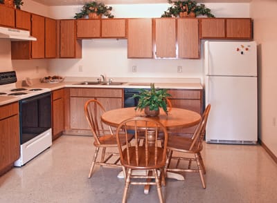 A cozy kitchen area with wooden cabinets and a table