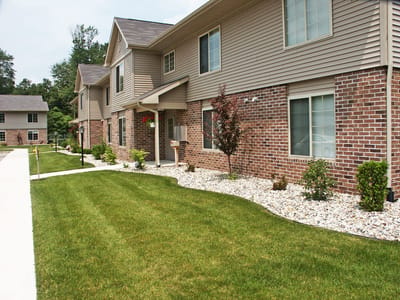 Exterior view of Whispering Pines Apartments with landscaped lawn