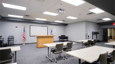 Spacious activity room with chairs and podium