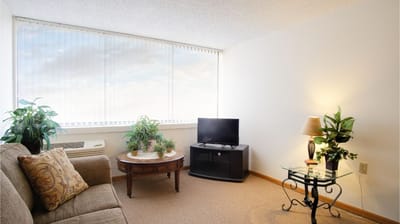Cozy interior of a senior living unit with plants and a TV