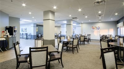 Bright dining room with tables and chairs set up