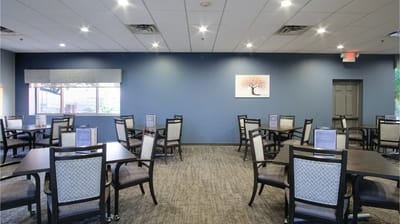 Bright dining room with tables and chairs set up