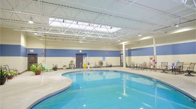 Indoor swimming pool area with seating and plants